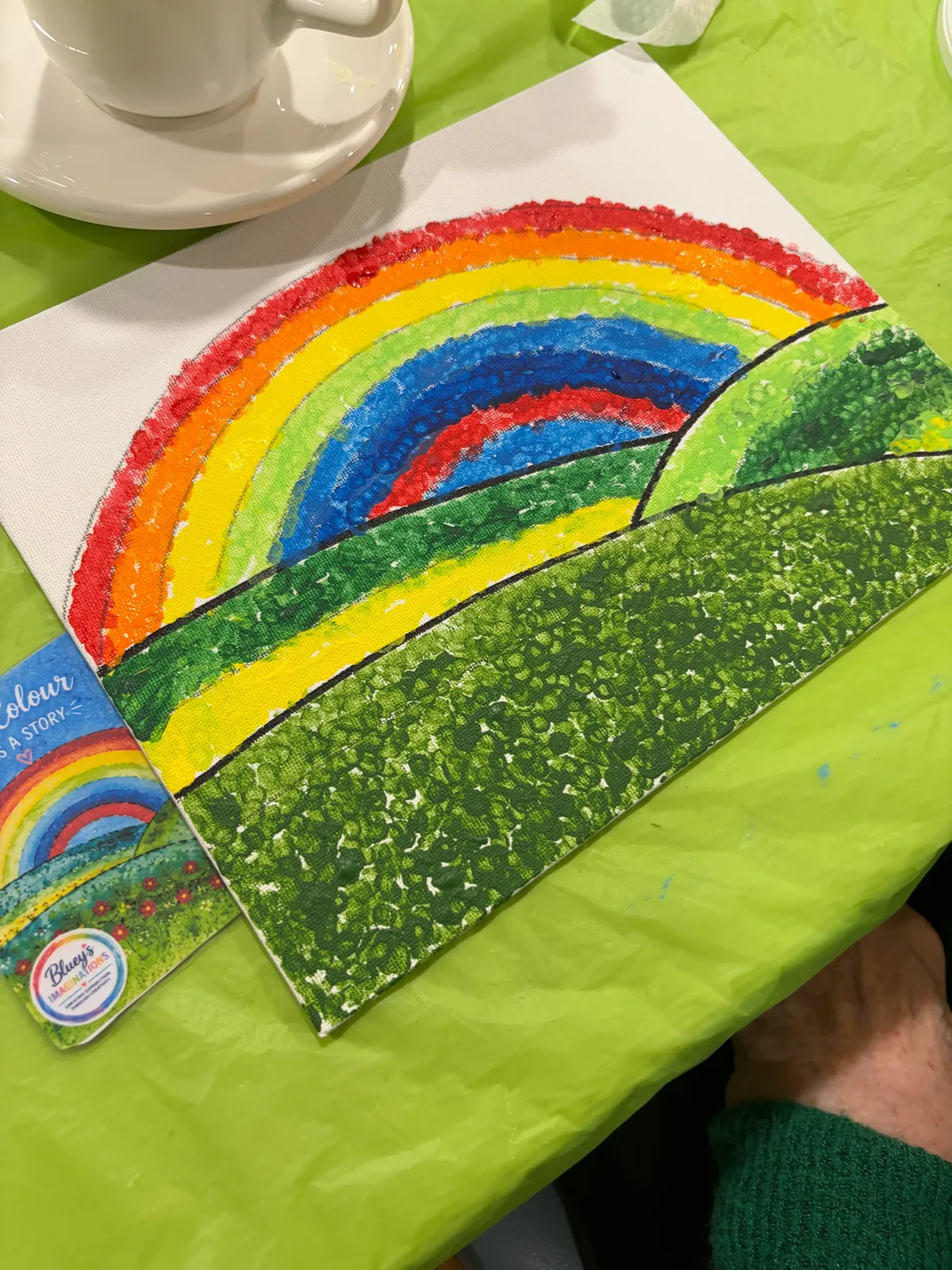A finished rainbow landscape painting created at an adult painting workshop
