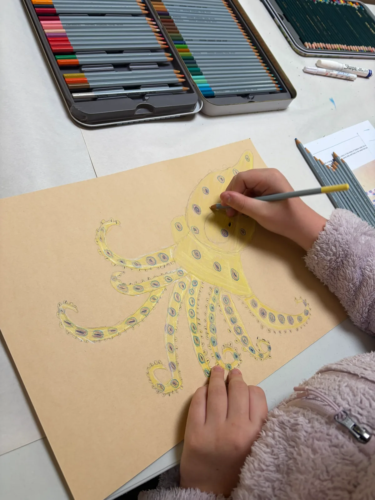 A young child painting a bright octopus artwork at a kids art and craft workshop