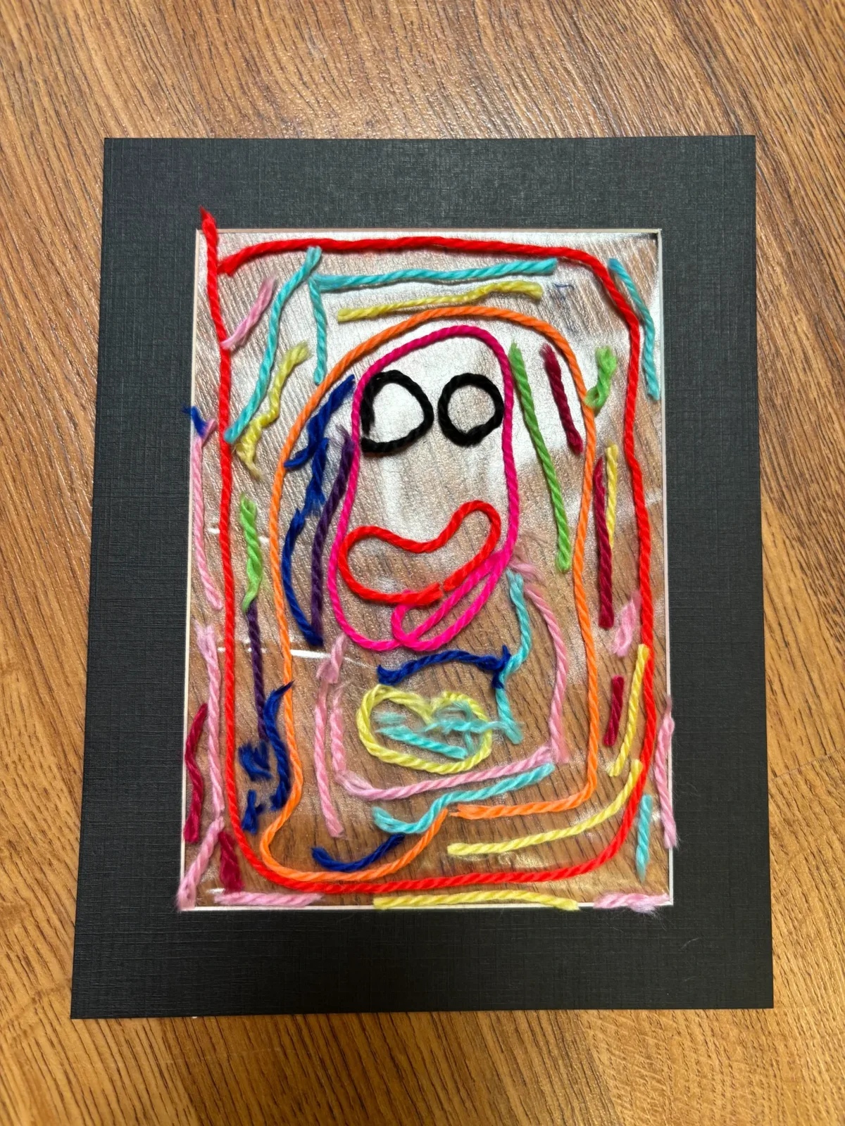 A colourful mosaic-style yarn artwork created by a child at a Bluey's Imaginations craft workshop